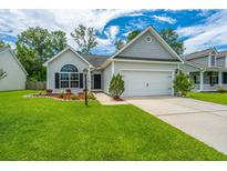 Charming single-story home boasts a well-manicured lawn, inviting curb appeal, and an attached two-car garage at 309 Hathaway Dr, Goose Creek, SC 29445