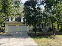Charming yellow home with a two-car garage and beautifully landscaped front yard with mature trees at 3646 Hilton Dr, Johns Island, SC 29455
