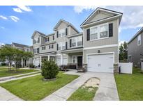 Well-manicured townhomes with attached garages, sidewalks, and landscaping, providing curb appeal at 4117 Rigsby Ln, Charleston, SC 29414