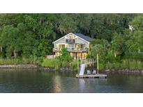 Stunning waterfront home featuring a private dock and lush surrounding landscape at 4940 Lambs Rd, North Charleston, SC 29418