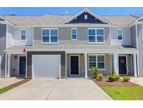 Inviting townhome exterior with a one car garage, gray tones, and well-manicured landscaping at 715 Hilchot Dr, Summerville, SC 29486