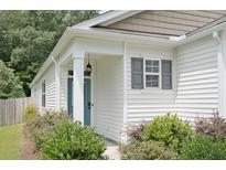 Charming home with a blue front door, gray shutters, and well-maintained landscaping at 9815 Seed St, Ladson, SC 29456