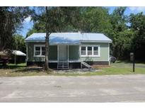 Charming cottage-style home featuring a light green exterior and a welcoming front porch at 103 Ann St, Saint George, SC 29477