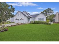 Charming white exterior with lush green lawn, garage, and manicured landscaping at 1075 Wayfarer Ln, Charleston, SC 29412