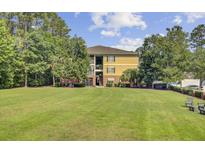 Inviting condominium building with lush green space and mature trees, offering a serene living environment at 1111 Basildon Rd, Mount Pleasant, SC 29466
