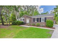 Charming brick home with a well-maintained lawn and mature trees draped in Spanish moss at 1225 Dennis Blvd, Moncks Corner, SC 29461