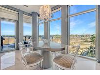 Bright dining area featuring a modern table and chairs, with floor to ceiling windows and marsh views at 149 Cooper River Dr, Mount Pleasant, SC 29464