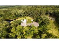 Overhead view of home with large barn and pond surrounded by mature trees at 1613 Cavanaugh Rd, Walterboro, SC 29488
