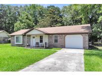 Charming single-story home with brick accents, a well-manicured lawn, and attached garage at 208 Janice St, Goose Creek, SC 29445