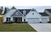 Charming new construction with white siding, gray accents, manicured lawn, and a two-car garage at 229 Huguenot Trl, Huger, SC 29450