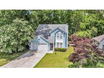 Charming two-story home featuring light blue siding, well-maintained landscaping, and an attached garage at 2773 Forest Dew Ct, Charleston, SC 29414