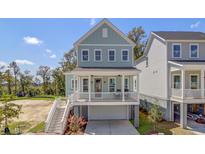 Charming two-story home with a welcoming front porch, staircase and a drive-under garage at 3049 Robeson Trce, Johns Island, SC 29455