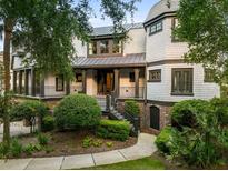 Charming home with shingle siding, a metal roof, a covered porch, and professionally landscaped front yard at 3121 Marshgate Dr, Seabrook Island, SC 29455