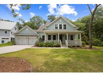 Charming two-story home featuring a welcoming front porch, complemented by a lush green lawn and manicured landscaping at 3226 Waverly Ln, Johns Island, SC 29455