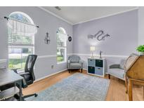 Inviting office space featuring hardwood floors, soothing gray walls, stylish decor, and abundant natural light from arched windows at 3257 Heathland Way, Mount Pleasant, SC 29466