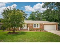 Charming brick home with a well-manicured lawn, mature tree, and an attached two-car garage at 43 Heathwood Dr, Charleston, SC 29407