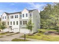 Charming townhome with gray siding, a one-car garage, and manicured landscaping on a sunny day at 501 Caledon Ct, Johns Island, SC 29455