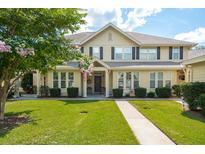 Inviting two-story home with a manicured lawn, charming front porch, and mature landscaping at 5511 Colonial Chatsworth Cir, North Charleston, SC 29418