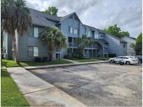Condominium complex featuring reserved parking and mature landscaping at 8483 Yadkin Cir # D, North Charleston, SC 29406