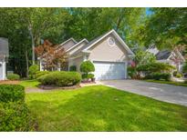 Charming single-Gathering home featuring a two-car garage, mature landscaping, and a well-manicured lawn at 9175 Spring Branch Ct, North Charleston, SC 29406