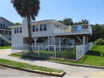 Inviting two-story home with a fenced yard and a charming balcony perfect for enjoying the coastal breeze at 1001 Palmetto Blvd, Edisto Island, SC 29438