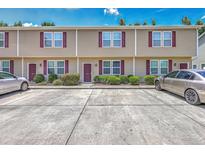 Well-maintained townhouse exterior with red shutters, landscaping, and private parking at 1064 Lexi Ct, Ladson, SC 29456