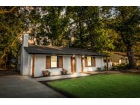 Charming brick home featuring a manicured lawn, wooden shutters, updated paint, and a new roof for great curb appeal at 1129 Dickson Ave, Hanahan, SC 29410