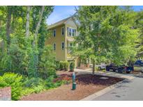 Charming yellow two-story home surrounded by lush greenery and well-manicured landscaping at 1184 Dingle Rd, Mount Pleasant, SC 29466