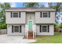 Charming split-level home features a tidy lawn, painted siding, and a bright green front door at 134 Hummingbird Ave, Ladson, SC 29456