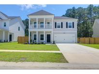 Charming two-story home with a welcoming front porch and well-manicured lawn at 1888 Nola Run, Summerville, SC 29485