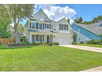 Charming two-story home featuring a manicured lawn, well-maintained landscaping, and a welcoming front porch at 2150 Terrabrook Ln, Charleston, SC 29412