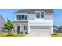 Two-story home with white siding, black shutters, well-manicured lawn, and a two car garage at 299 Lucca Dr, Summerville, SC 29486