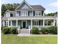 Charming two-story home with a welcoming front porch, beautiful blue siding, and well-maintained landscaping at 3513 Flowering Oak Way, Mount Pleasant, SC 29466