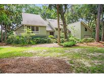 Charming exterior of home surrounded by lush landscaping and mature trees providing shade and character at 40 Greensward Rd, Kiawah Island, SC 29455