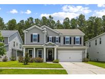 Charming two-story home with gray siding, black shutters, and a well-manicured front lawn at 423 Sanctuary Park Dr, Summerville, SC 29486