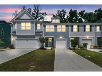Charming townhome with gray siding, white garage doors, and well-maintained landscaping at sunset at 493 Trotters Ln, Moncks Corner, SC 29461
