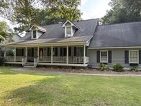 Charming single-Gathering home featuring a welcoming front porch and mature landscaping at 843 Parrot Creek Way, Charleston, SC 29412