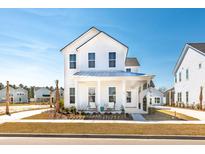 Charming two-story white home featuring a covered porch and beautifully landscaped front yard at 114 Battle Boat Blvd, Summerville, SC 29485