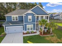 Charming two-story home with blue siding, a gray roof, an attached garage, and lovely landscaped front yard at 202 Buttercup Ln, Summerville, SC 29486