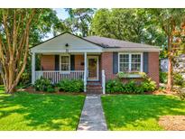 Charming brick home with a manicured lawn and inviting front porch with flower boxes at 31 Lyttleton Ave, Charleston, SC 29407