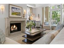 Bright living room featuring a stone fireplace, hardwood floors, and designer furnishings at 32 Prioleau St # J, Charleston, SC 29401