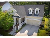 Charming home featuring a welcoming front porch, attached two car garage, and beautifully landscaped yard at 3537 Crosstrees Ln, Mount Pleasant, SC 29466