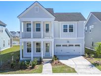 Charming two-story home with a light blue exterior, balcony, and attached two car garage at 444 Parish Farms Dr, Summerville, SC 29486