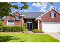 Charming red brick home with a manicured lawn, arched entryway, and attached garage at 5008 Northfield Ct, Charleston, SC 29414