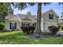 Charming home with mature trees, manicured lawn and window shutters at 5011 W Liberty Meadows Dr, Summerville, SC 29485