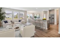 Bright, open-concept living room featuring a modern kitchen with a breakfast bar, stainless steel appliances, and hardwood floors at 515 Cropfield Dr, Summerville, SC 29485