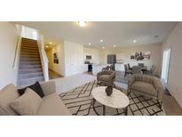 Open-concept living room featuring modern decor and seamless flow to the dining and kitchen areas at 5302 Bending Flats Way, Summerville, SC 29485
