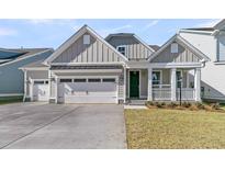 Charming home with a two-car garage, a covered front porch, and a well-manicured lawn at 762 Maynard Ln, Summerville, SC 29486