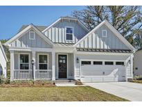 Charming light blue two-story home with an attached garage and welcoming front porch at 770 Maynard Ln, Summerville, SC 29486