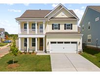 Charming two-story home with yellow siding, a front porch, white columns, and a two-car garage at 774 Maynard Ln, Summerville, SC 29486
